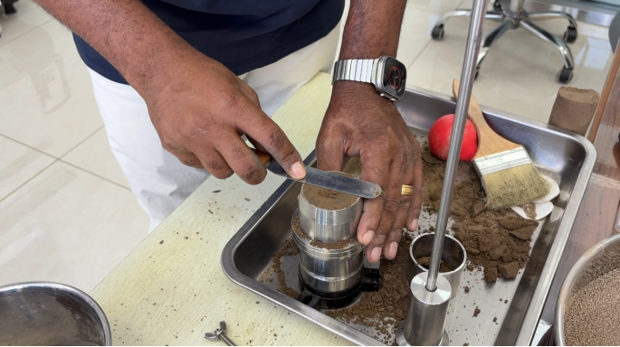The customer carefully trims a soil specimen, achieving a clean, flush edge — a detail that reflects his precision and patience.