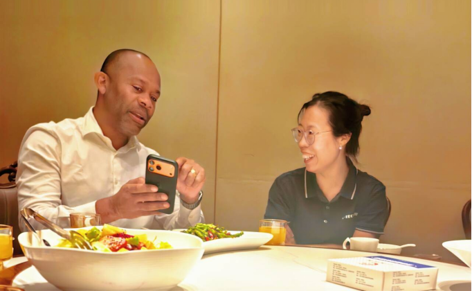 A relaxed moment between the customer and our Sales Manager, Ms. Sarah, chatting over a lunch break before the food arrives.